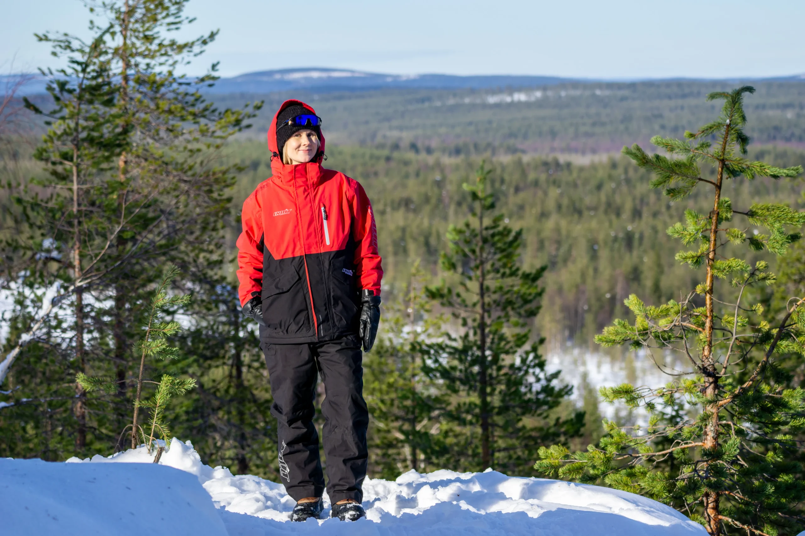 Guest on a snowy hilltop with forest stretching to the horizon