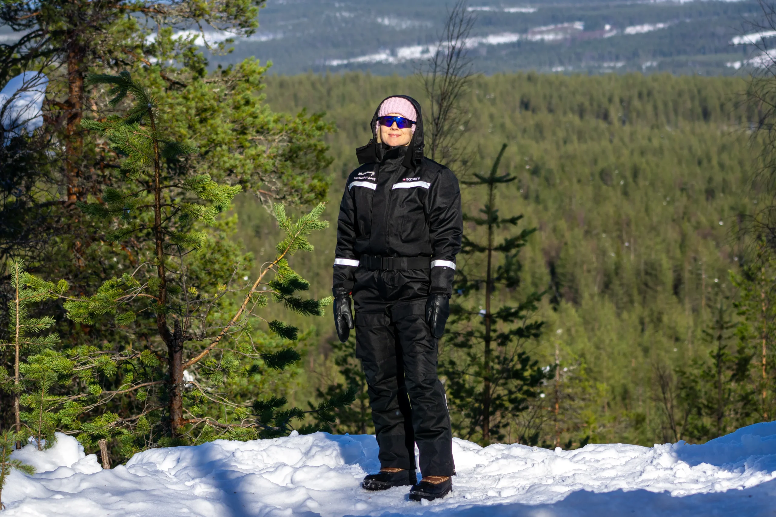 Guest standing at a snowy viewpoint above endless forest